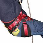 A close-up of a red and black Buckingham AussieMasters climbing or safety harness worn around a person's leg and hip, with metal D-rings and straps visible against a plain white background.